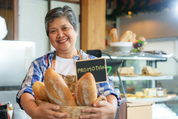 Business owner, small cafe, retired woman on pension Standing with a bright smile holding a basket...