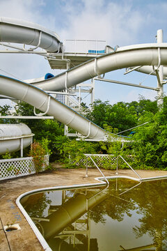 Abandoned Water Slide and Overgrown Plants at Quiet Park - Ground View
