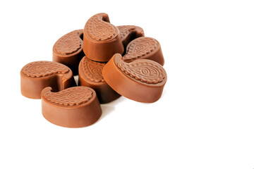 Milk chocolate candies lie on a white isolated background.