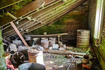 Rusty Barrels in Abandoned Industrial Building with Moss Overgrowth