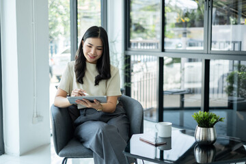 Female CEO in casual wear smiling and using tablet working Shown on the digital screen analyze and calculate the planning strategy for modern business