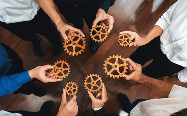 Business team joining cogwheel in circular together symbolize successful group of business partnership and strong collective unity teamwork in community workplace with productive efficiency. Prudent