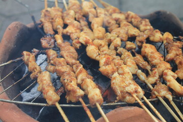 The process of grilling chicken satay on a traditional stove