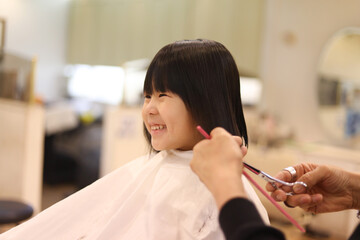 美容室で髪の毛を切る女の子