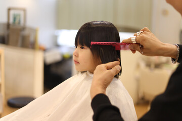 美容室で髪の毛を切る女の子
