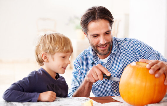 Father, child and carving pumpkin with knife to celebrate halloween, fun craft and creativity at home. Happy boy kid, dad and family cutting orange vegetable for holiday lantern, party and decoration