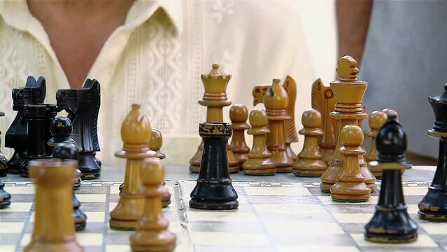 Two Retired Gentlemen Enjoy a Game of Chess Outdoors. Close Up. 4K Resolution.