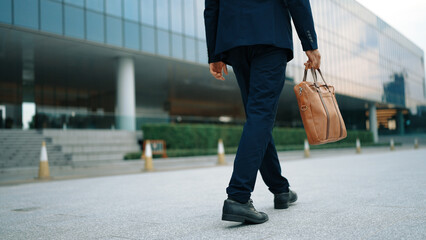 Closeup of skilled business man leg walking while holding bag. Cropped image of project manager focus on leg. Traveling, moving, journey, getting a new position, job changing. Back view. Exultant. - Powered by Adobe
