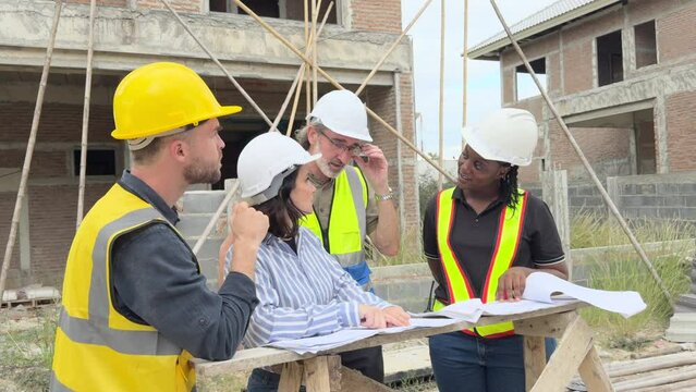 Team of construction contractor talking - discussing about the building plan together at construction site. 