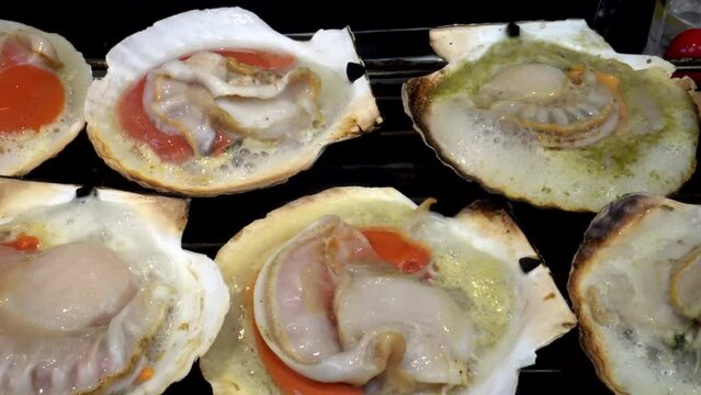 Grilling fresh seafood Japanese scallop hotate at fish market street food of Japan 4k