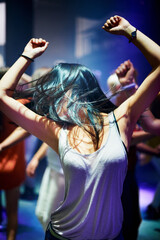 Woman, dancing and music at rave, happy and party in nightclub, festival and dj event. Disco, rock and freedom with excited girl in crowd of fans for celebration, energy and techno performance