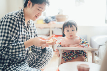 Obraz na płótnie Canvas 離乳食を食べさせるお父さんと赤ちゃん