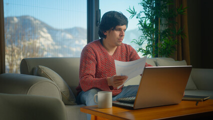 Man sit on couch in living room with laptop pay bills, use calculator count expenses, make budget control, manage finances, review overdue loan payments feel stressed