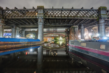 The old Castlefield viaduct and one of the canals in Manchester at night