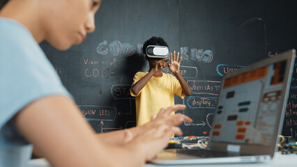 Closeup of school girl hand coding program while african student using VR interact with metaworld....