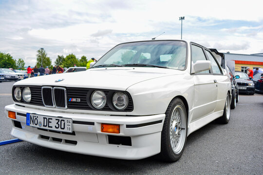 Front of a white BMW e30 M3 vintage car with headlights, fenders, indicators and fog lights at the BMW meeting, Gollhofen, Bavaria, Germany May 30, 2021