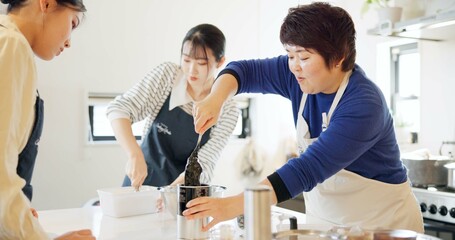 Cooking class, restaurant and women with Japanese teacher and food in a kitchen learning professional skill. Student, education and Asian cuisine course with people together working on skills