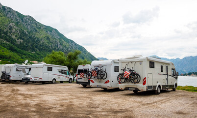 Group of motorhome vans parked at coast with sea view. Kotor bay, Montenegro