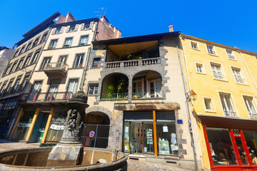 Streets of Clermont-Farrand in afternoon. Shops and residentioal buildings along walkway.