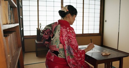 Traditional, writing and Japanese woman in home for script on paper, documents or page on desk. Creative, Asian culture and person with vintage paintbrush, ink and tools for calligraphy, font or text