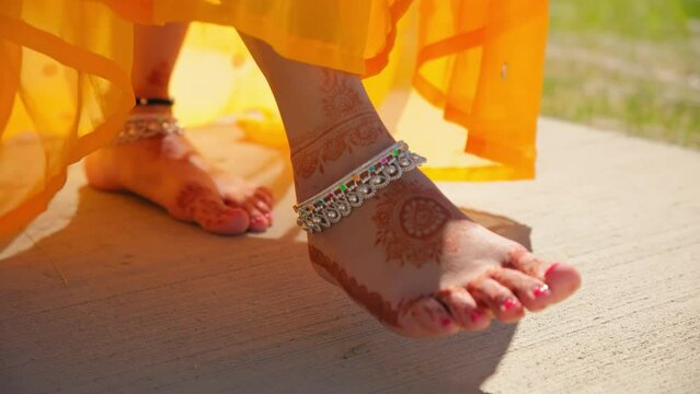Close up view of woman in traditional Indian dress hindu wedding goes barefoot on the street. Move camera