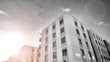 Fragment of the building's facade with windows and balconies. Modern apartment buildings on a sunny day. Facade of a modern residential building. Black and white.