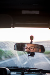 Adult senior woman driving a car looking at the road and using eyeglasses to see better - concept of drive vehicle -  insurance and travel old mature people