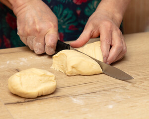 A woman cuts dough with a knife