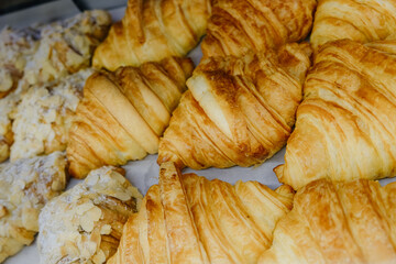 Close-up of golden croissants in a bakery display.