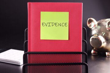EVIDENCE text on a yellow sticker pasted on an upright diary on a black background