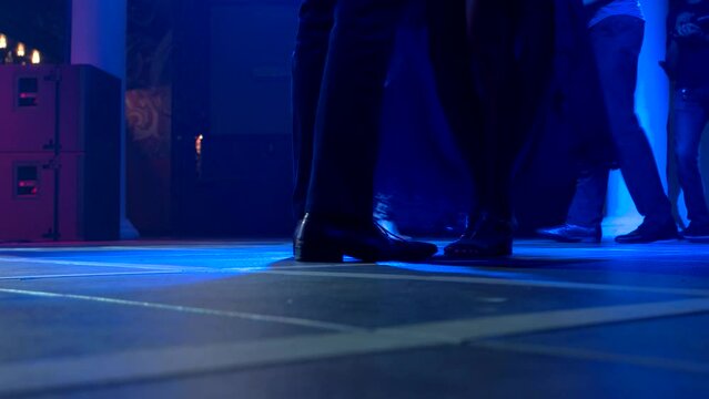 Legs of couple dancing. People and blue light. Let's dance together. Spend night at the club.