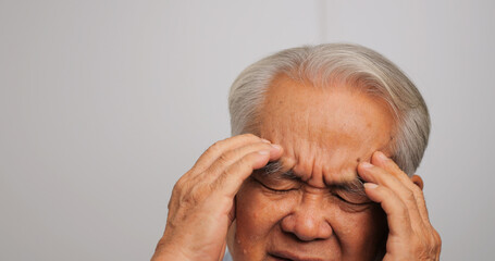 Asian old man with migraine headache. Elderly man suffering from a headache.