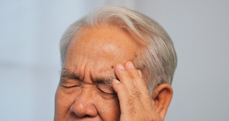 Asian old man with migraine headache. Elderly man suffering from a headache.