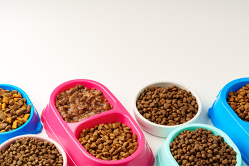 Plastic pet bowls with food isolated on white background