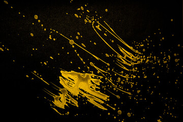 gold paint splatter on a black background