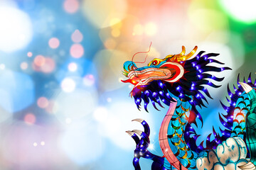 Traditional chinese dragon on festive blur bokeh background. Statuette of dragon, New Year symbol