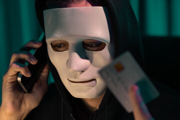 White criminal anonymous mask calling to credit card owner to threaten ransom with privacy...