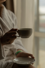 Female hands holding a cup indoors