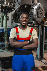 Fototapeta premium Portrait of young african man car service worker wearing uniform standing in garage