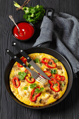 omelette with vegetables in a pan, top view
