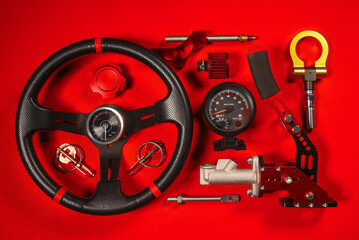 Sport car tuning equipment and spare parts on red top view background. Motorsport concept...
