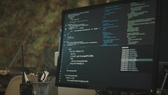 No people shot of html code running on black background of computer monitor standing on desk in dark secret military control center workplace