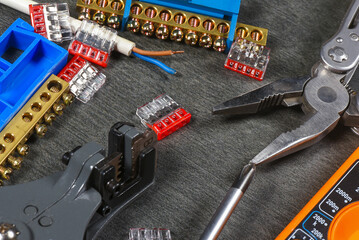 Various electrical terminal blocks, wiring connectors on the gray workbench flat lay background with copy space. Electrical works.