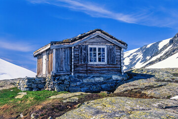 Old wooden cabin on a mountain in sunshine