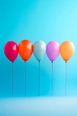 Row of balloons with blue background behind them,.