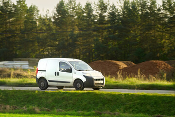 Fototapeta premium delivery van. A mockup of a white commercial vehicle isolated on the road. Perfect for your business and shipping needs.