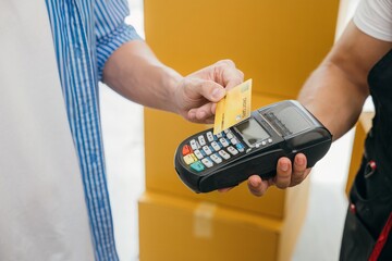 Family completes the move paying via credit card. Worker holds a box. Professional movers ensure...