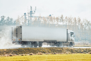 A White Truck Driving on the Highway in a Downpour as It Carries Out Its Transportation Business.