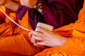 lose up monk's hand holding holy thread, buddhist holy day, thai buddhist monk ordination ceremony...