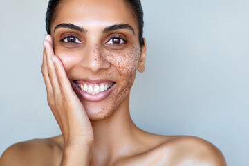 Skin care beauty portrait.  Facial scrub young happy Indian or sough asian woman is posing with...